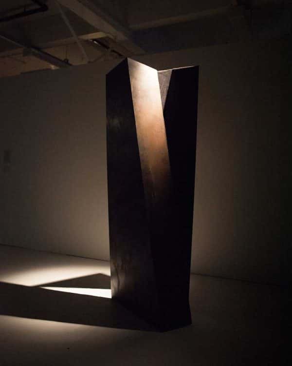 Chrissy Leech - Image of bronze tall sculpture lit by a lamp above it in a fine art studio space at NUA