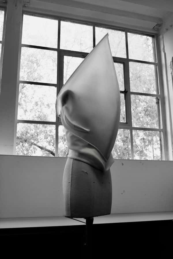 Amy Ollet - Greyscale photo of fabric structure which covers the head