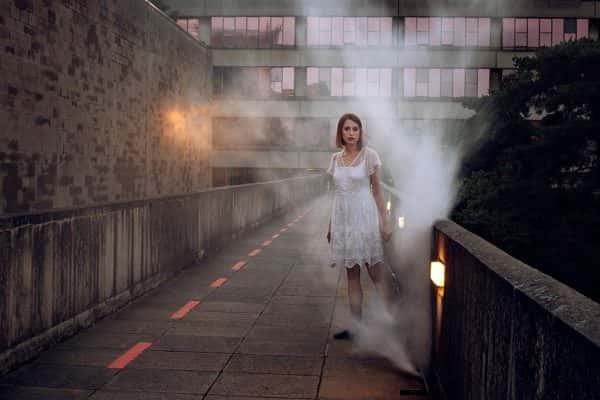 Jensdottir Gudbjorg - mist rises above a concrete walkway where someone stands in a white dress