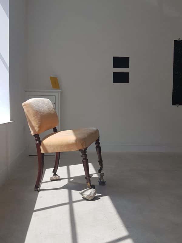 Kate Florence Knowlden - A chair and a rock in the sun through a window