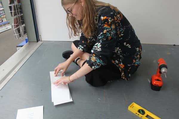 Megan Ryder - Student sitting on the floor preparing their work