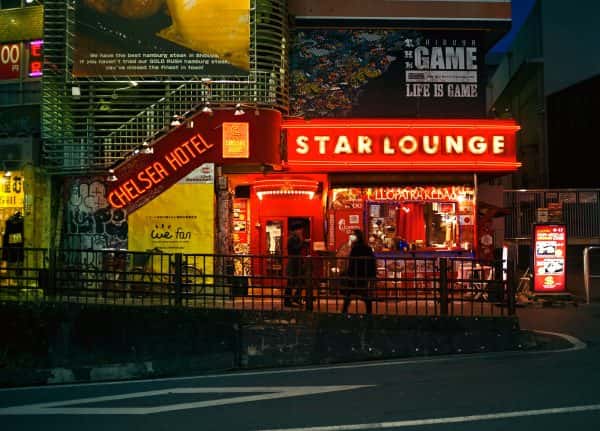 Jason Cleaver - Image of a busy city street in Tokyo with shops with bright neon lights