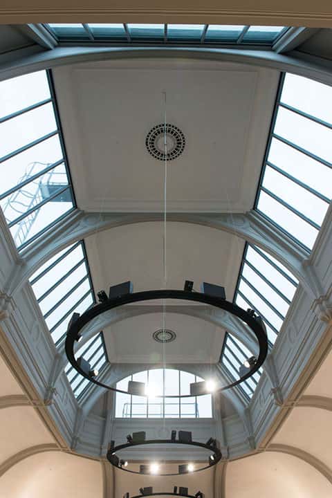 photo of NUA building boardman house shows atrium skylight with large amounts of light pouring in and circle lighting fixtures