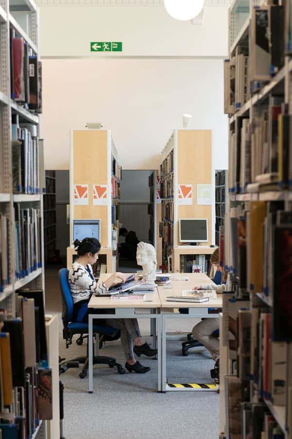  - Image of a student working at a desk in the library