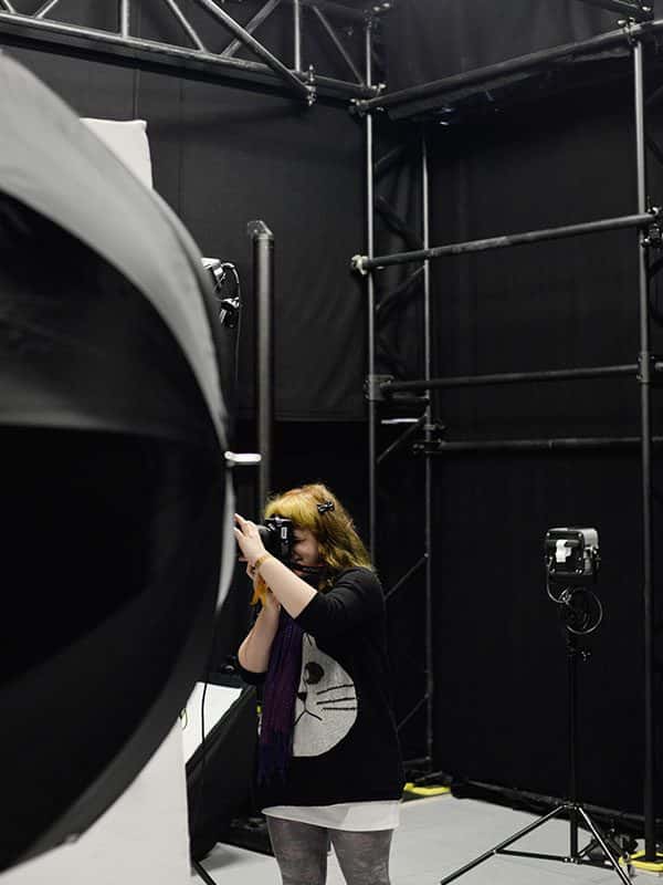  - Image of a student shooting in the photography stdio