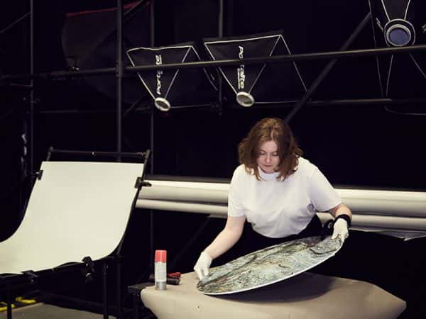  - A student sets up a background in a photography studio at Norwich University of the Arts