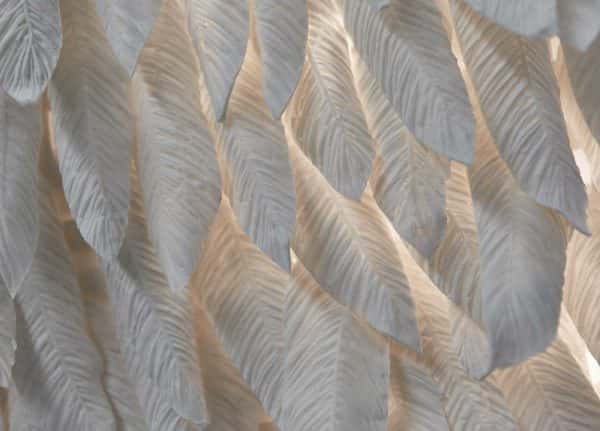 Rachel Harrison - Image of crafted white feathers arranged in a close close pattern on a wall