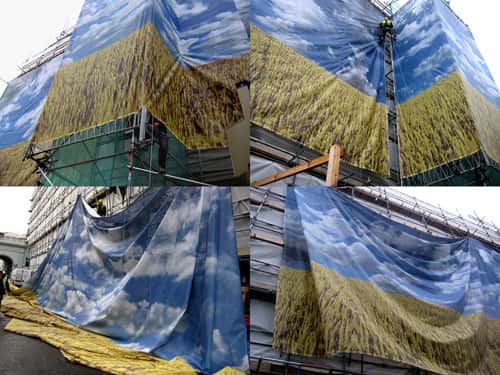 Wrapping the Corn Exchange - Four photographs within the same image of installation shots of the Corn Exchange being wrapped in fabric printed with a blue sky and field of yellow corn