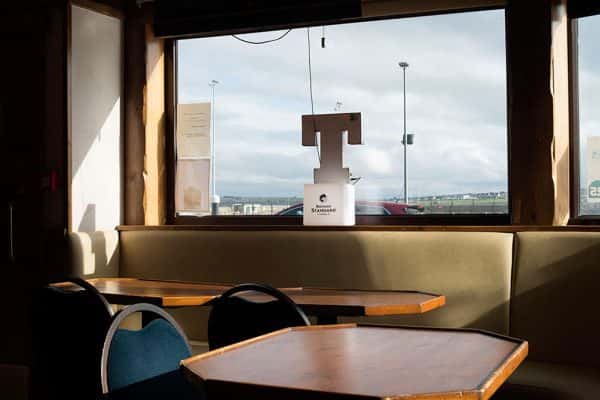 500 Miles from Home - Interior photograph of tables and chairs and a window by Ross Trevail