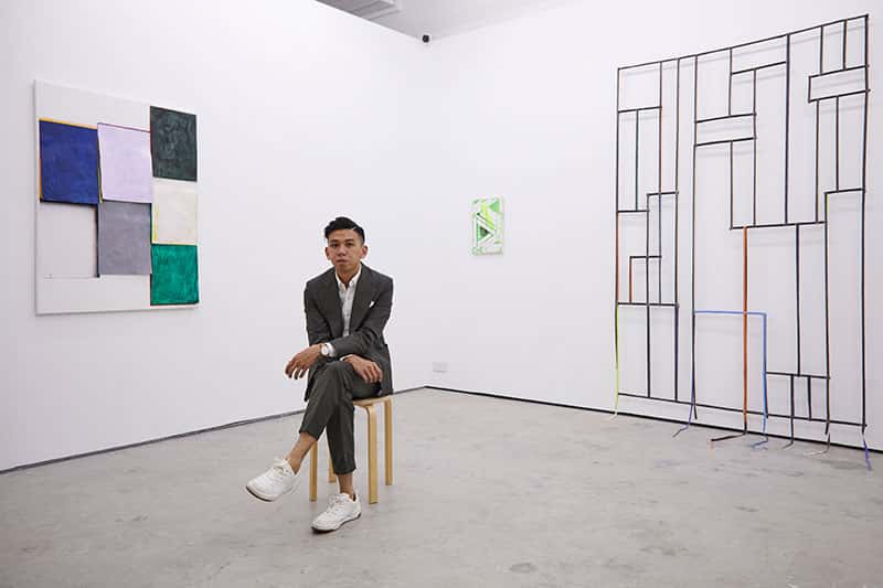 Gabriel Loy, Fine Art graduate at Norwich University of the Arts sat in his gallery 1961 in Singapore