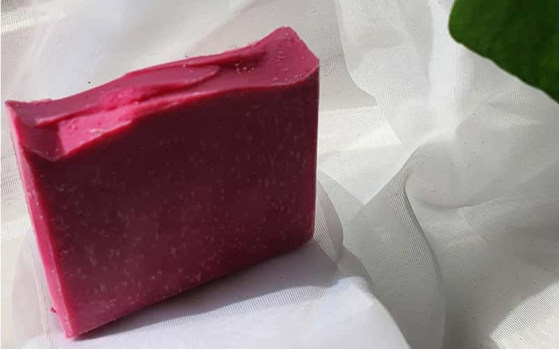 cherry coloured soap bar with white fabric in background