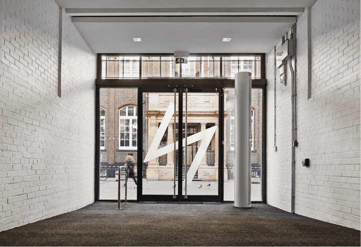The glass doors at the entrance of the Gunton's Building. The photo is taken from inside, so the large N NUA logo is reversed