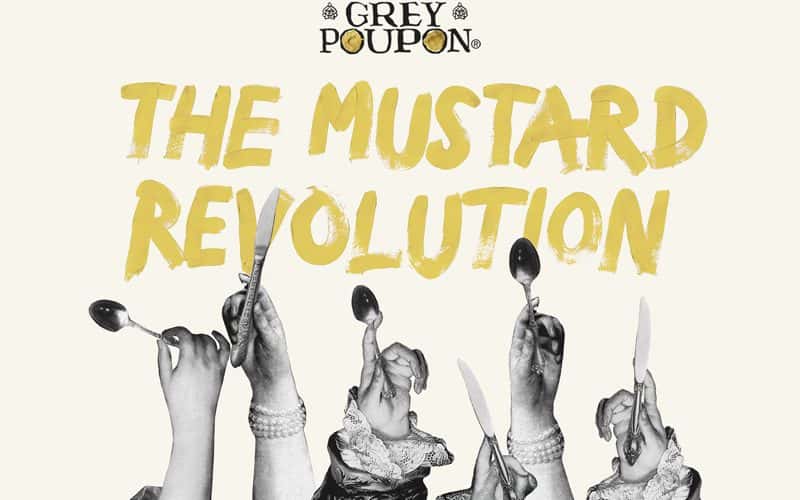 Five cutout black and white photos of royalty's hands, all holding cutlery pointing upwards. Above the collage, in brushed typography are the words 'The Mustard Revolution', coloured mustard yellow. Above this, the Grey Poupon logo.
