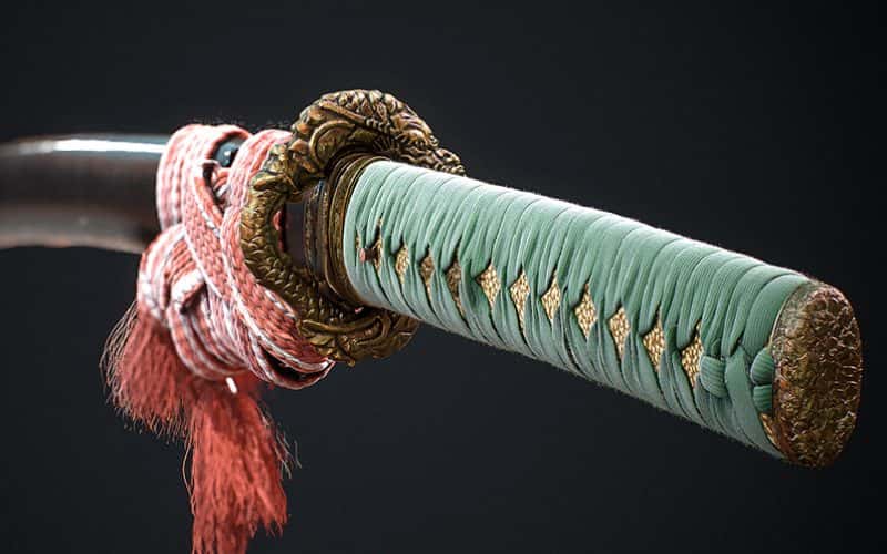 Image of 3D rendered sword with green handle and pink rope knotted around the blade