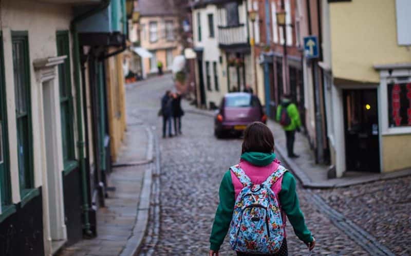 Image showing person with backpack walking down cobbled hill